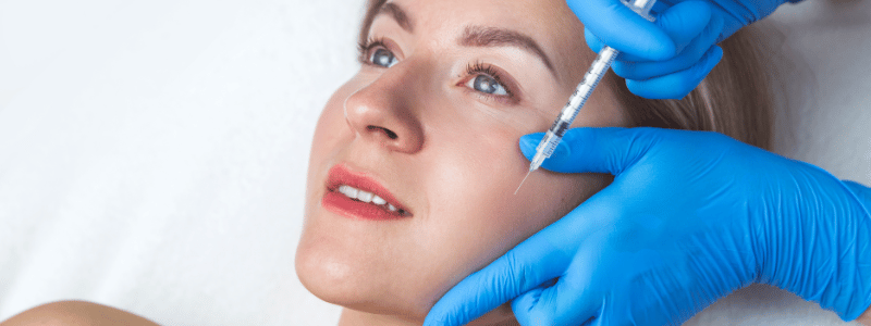 A woman receiving a PRP injection in her cheek 