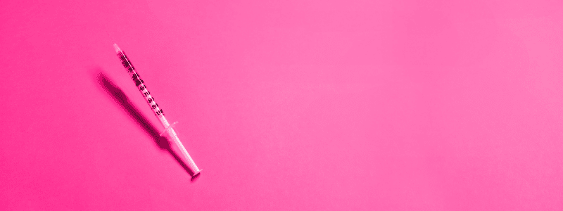 PRP Injection syringe on a pink background